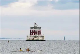  ?? SARAH GORDON/THE DAY ?? Kayakers paddle through Long Island Sound past Ledge Light on Tuesday as seen from Eastern Point in Groton.