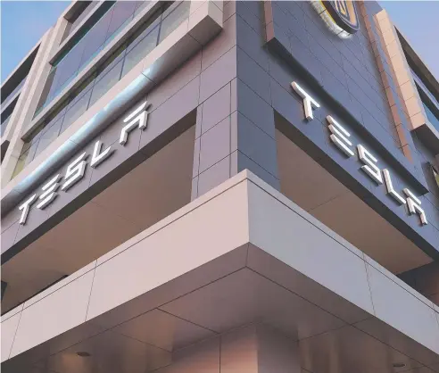  ?? Picture: GETTY IMAGES ?? GOING OFFSHORE: The Tesla name is seen on the exterior of a dealership in Miami, Florida. Tesla is ready to build a mega-production facility in Shanghai, China.