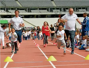  ?? (Harsin/Sipa) ?? Children running with Tony Estanguet and Patrick Baumann, Stade de France, Saint-Denis, 15 May.