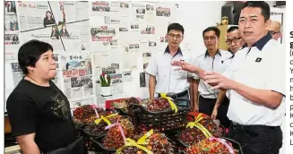  ??  ?? Season ofgiving: Tan (right) and other MCA Youth members handing over baskets of oil palm fruits at Kok’s service centre in Kuala Lumpur.