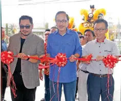  ??  ?? From left, Arif, Masidi and Shinnishi cut the ribbon to mark the opening of Sabah’s first Mitsubishi 4S Centre.