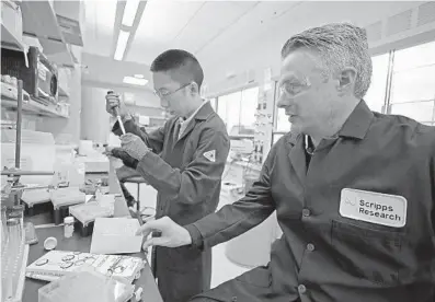  ?? PHOTOS BY JOHN MCCALL/SUN SENTINEL ?? Professor Matthew Disney works with postdoctor­al researcher Jon Chen at the Scripps Research Institute-Florida in Jupiter on Thursday. Disney and his research team developed a compound that could help make breast cancer patients more receptive to treatment.