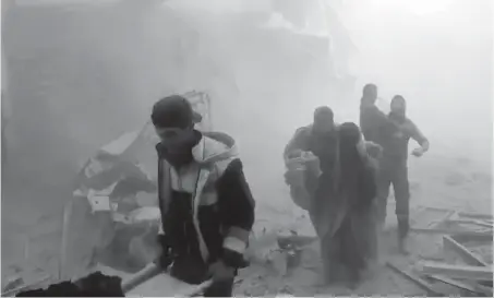  ??  ?? A still from video released on Saturday by Syrian Civil Defence group the White Helmets shows its members helping residents during airstrikes and shelling by Syrian government forces, in Ghouta, a suburb of Damascus. A new wave of airstrikes and...