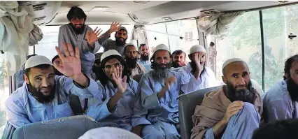  ??  ?? In this handout photograph, taken and released on May 25, 2020 by Afghanista­n’s National Security Council, Taliban prisoners wave inside a vehicle during release from the Bagram prison, next to the US military base in Bagram, north of Kabul.