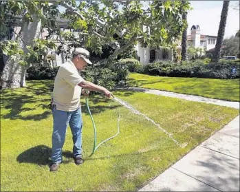  ?? Mel Melcon ?? A GARDENER waters the lawn of a home in Beverly Hills, where most residents will have to cut their water use 30%. “Beverly Hills is determined to meet the new water conservati­on goals,” the mayor says.