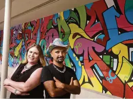  ?? R. Clayton McKee / For the Chronicle ?? Artist Gonzo247 and Pamela Vargas, Rice Village assistant general manager, stand before Gonzo247’s mural “It’s a Good Day to Have a Good Day,” painted on a wall next to the Black Walnut Café, 5510 Morningsid­e Drive.