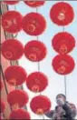  ?? AFP ?? A man installs Chinese lanterns ahead of the Lunar New Year, in Beijing.