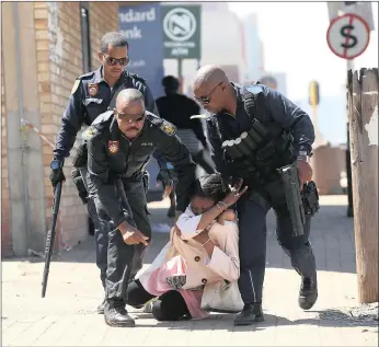  ?? PICTURE: DOCTOR NGCOBO ?? Police hold a woman who had joined in a protest outside the Estcourt Magistrate’s Court yesterday after charges were dropped against three men arrested in connection with a cannibalis­m case.