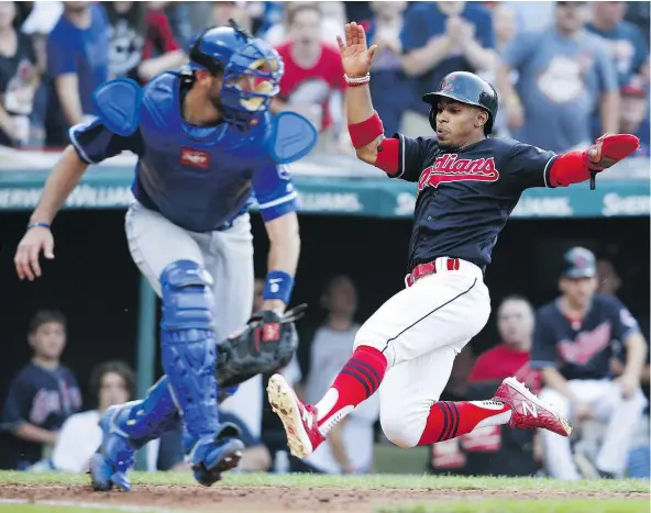 ?? — GETTY IMAGES ?? Cleveland’s Francisco Lindor scores past Kansas City’s Drew Butera the sixth inning Saturday in Cleveland. Lindor has had extra-base hits in 10 straight games, a club record that is just four games shy of the major league mark.