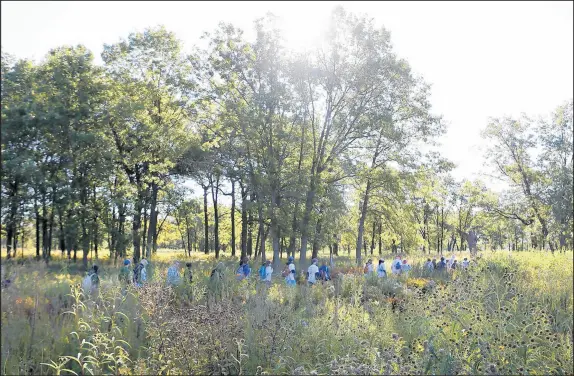  ?? SUZANNE TENNANT/POST-TRIBUNE ?? Local environmen­talists begin their walk Saturday to protest the dangers of the tar sands oil pipeline that runs below Hoosier Prairie State Nature Preserve in Scherervil­le.