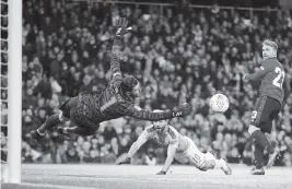  ?? DAVE THOMPSON AP ?? Manchester United’s goalkeeper David de Gea dives to make the save of a shot by Man City’s Sergio Aguero, center, during the English League Cup semifinal Wednesday.