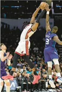  ?? MATT KELLEY/AP ?? Heat center Bam Adebayo, center, reaches for the ball against the Hornets in the Heat’s loss on Saturday. The Heat shot 40% from the field overall Saturday as an early shooting slump put the team in a deep hole.