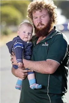  ??  ?? HERO NOMINATION: Toowoomba dad Jeremi Simpson with seven-month-old Kaiden at home in Toowoomba. Mr Simpson is being hailed as a hero after taking down a knife wielding robber at Woolworths.
