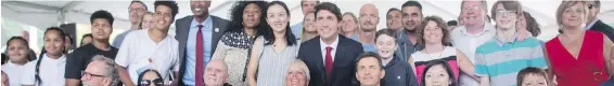  ?? DARRYL DYCK, THE CANADIAN PRESS ?? Prime Minister Justin Trudeau, centre, poses for a photograph with new Canadians after addressing a citizenshi­p ceremony in Kelowna.