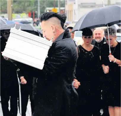  ??  ?? Paul Black kisses the coffin of daughter Pearl Melody Black as he carries her into the Jerusalem Baptist Church in Merthyr
