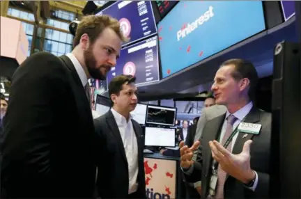  ?? RICHARD DREW — THE ASSOCIATED PRESS ?? Pinterest co-founder & CEO Ben Silbermann, center, and fellow co-founder and chief product officer Evan Sharp, left, meet with specialist Glenn Carell on the New York Stock Exchange trading floor Thursday before the company’s IPO.