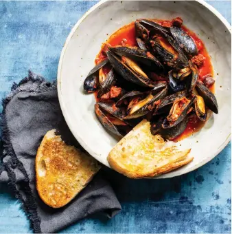  ?? COURTESY OF AMERICA’S TEST KITCHEN ?? Mussels can be cooked with Spanish chorizo and tomatoes and served on garlic toast.