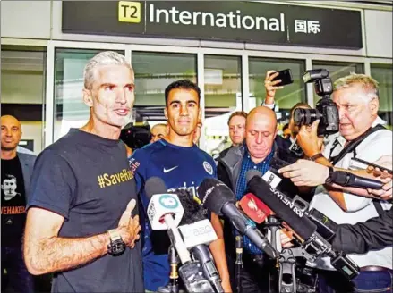  ?? WILLIAM WEST/AFP ?? Former Australian football captain Craig Foster (left) speaks to the media beside Hakeem al-Araibi upon his arrival in Melbourne on Tuesday. The refugee footballer returned to Australia ending a two month ordeal that saw him jailed in Thailand.