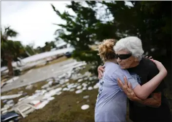  ?? AP PHOTO/REBECCA BLACKWELL, FILE ?? Tina Brotherton, 88, gets a hug from 9-year-old neighbor Lainey Hamelink, as she returns to site of her business, Tina’s Dockside Inn, which was completely destroyed in Hurricane Idalia, as was Brotherton’s nearby home, in Horseshoe Beach, Fla., Friday, Sept. 1, 2023, two days after the storm’s passage.