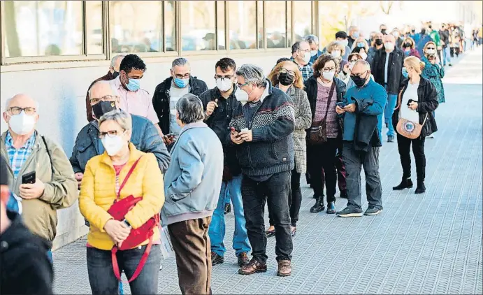  ?? ALEJANDRO GARCÍA / EFE ?? Ahir és va reprendre la vacunació amb AZ per a persones de 60 a 65 anys i es van formar llargues cues de convocats, com aquesta al centre de primària Casernes