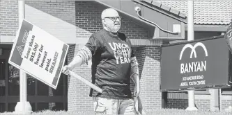  ?? SCOTT GARDNER THE HAMILTON SPECTATOR ?? An OPSEU Local 216 member holds a picket sign at the Arrell Youth Centre on Anchor Road Monday. Banyan, the not-for-profit organizati­on that runs the centre, locked out staff Friday after contract talks broke down.
