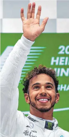  ?? FOTO: AFP ?? Nein, es ist nicht zum Haareraufe­n: Lewis Hamilton fühlt sich pudelwohl in Schanghai – nach seinem fünften Sieg noch ein bisschen mehr.