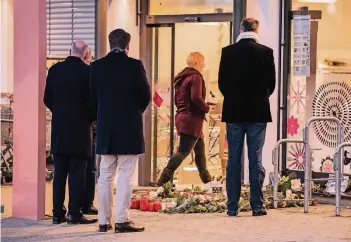  ?? FOTO: DPA ?? Vor dem Drogeriema­rkt in Kandel (Rheinland-Pfalz) legen Trauernde Kränze nieder und zünden Kerzen an.