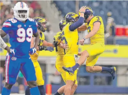  ?? | TOM PENNINGTON/ GETTY IMAGES ?? Quinn Nordin ( 3) and Michigan teammate Garrett Moores whoop it up after one of Nordin’s four field goals.