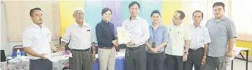  ??  ?? Zee Yeng (third left) presents Grade A certificat­e to the manager of Sugarbun outlet as others look on.