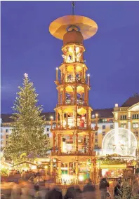  ?? FOTO: DPA ?? Ein beliebtes Reiseziel in der Vorweihnac­htszeit ist der Striezelma­rkt in Dresden mit seiner 14 Meter hohen Pyramide.