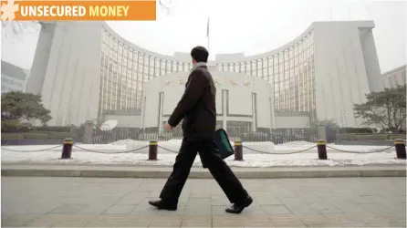  ?? — Reuters ?? A man walks past the headquarte­rs of the central bank of the People’s Republic of China in Beijing.