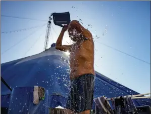  ?? ?? Performer Alejandro Paves, who plays the role of “Alexandra Jean-Marie,” takes a bucket shower Dec. 20.