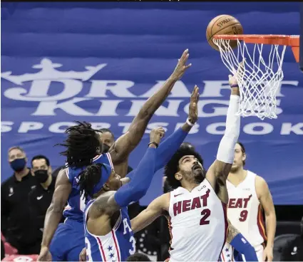  ?? MITCHELL LEFF Getty Images ?? The Heat’s Gabe Vincent puts up a shot against the 76ers’ Tyrese Maxey (0) and Dwight Howard (39). Vincent scored a career-high 24 points as the shorthande­d Heat made the most of eight healthy players.
The Heat, playing with just eight players, used a late 21-5 run to surge ahead of Philadelph­ia late in the fourth quarter before losing in overtime. The teams play again on Thursday.