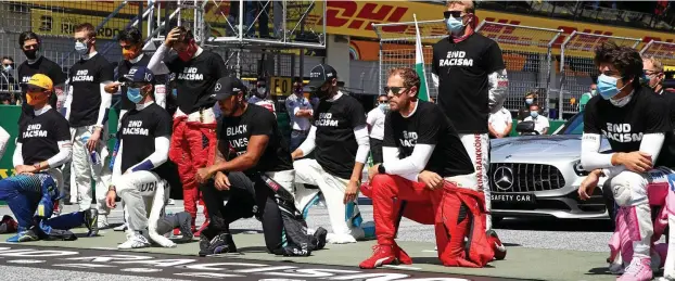  ?? FOTO: AFP ?? Protest vor dem Start: 14 der 20 Fahrer beteiligte­n sich mit einem Kniefall an der „Black Lives Matter“-Bewegung – unter anderem auch Lewis Hamilton und Sebastian Vettel (rote Hose).