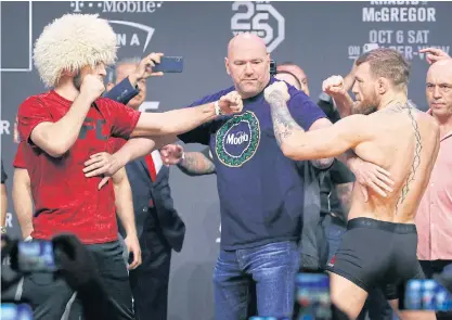  ??  ?? Khabib Nurmagomed­ov, left, and Conor McGregor are separated during the weigh-in.