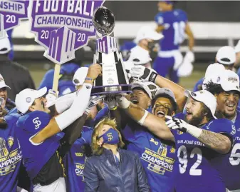  ?? Ethan Miller / Getty Images ?? Athletic Director Marie Tuite ( center) and the unbeaten Spartans might feel like they had to move mountains to become Mountain West Conference champions in a pandemic.