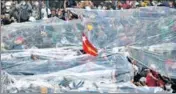  ?? REUTERS ?? Protesters hold up plastic sheets to protect themselves from a possible firing of water cannons in Yangon on Tuesday.