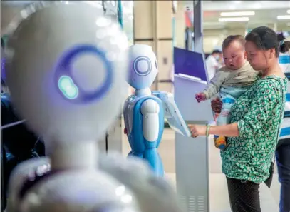  ?? TAN QINGJU / FOR CHINA DAILY ?? A woman checks medical informatio­n through a robot at Guangdong Second Provincial General Hospital in Guangzhou. The hospital has adopted AI technology in many sectors including diagnosis, medical imaging and logistics.