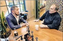  ??  ?? Former Farmers Bank president and CEO Aaron Johnson, left, talks with his father, Larry, at the coffee bar built in their new Midtown branch in this May 15, 2018, photo. A few months later, both men stepped down amid allegation­s of fraud and a consent order from the FDIC. The Johnson family owned and controlled the bank for more than 60 years. [CHRIS LANDSBERGE­R/ THE OKLAHOMAN]