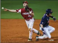  ?? AP/The Oxford Eagle/BRUCE NEWMAN ?? Arkansas’ Carson Shaddy (20) throws to first base to turn a double play after forcing out Mississipp­i’s Will Golsan on Thursday during the No. 6 Razorbacks’ 6-4 victory over the No. 4 Rebels in Oxford, Miss.