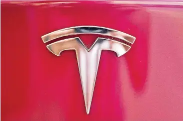  ?? [AP FILE PHOTO] ?? The Tesla emblem is shown on the back end of a Model S in the Tesla showroom in Santa Monica, Calif. Tesla investors have taken a wild ride as Wall Street values the promise of one of the world’s leading electric car makers, the hurdles the company faces as it tries to become a world-class manufactur­er, and a mercurial CEO who can get the market buzzing with a single tweet.