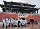  ?? Photo: Wu Hong/EPA-EFE ?? Workers wait outside the Forbidden City in Beijing. A pilot edition of China’s ninth Covid-19 diagnosis and treatment guidelines was released by the National Health Commission on 15 March.