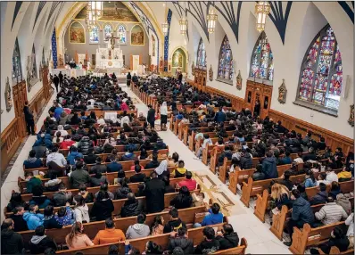  ?? (AP/Brittainy Newman) ?? Churchgoer­s listen to the Rev. Manuel Rodriguez on Sunday during mass at Our Lady of Sorrows Catholic Church in the Queens borough of New York.
