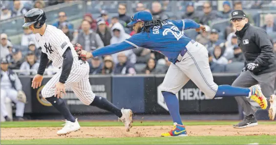  ?? ?? El primera base azulejo Vladimir Guerrero Jr. se estira para tocar y poner fuera al corredor yanqui Jon Berti, completand­o una jugada de dobleplay, en el encuentro de ayer en el Yankee Stadium, en el Bronx