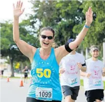  ?? SUBMITTED PHOTO ?? Parkland’s Denise Harrison, 48, raises her hands in celebratio­n as she completes her 50th long-distance running event, the Eau Palm Beach Half Marathon, before her 50th birthday.