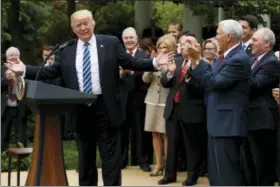  ?? ASSOCIATED PRESS ?? President Donald Trump, accompanie­d by GOP House members, speaks in the Rose Garden of the White House in Washington Thursday after the House pushed through a health care bill.