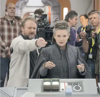  ?? LUCASFILM ?? Rian Johnson, left, directs Carrie Fisher while shooting The Last Jedi.