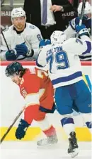  ?? WILFREDO LEE/AP ?? Tampa Bay Lightning center Ross Colton (79) slams Panthers defenseman Josh Mahura into the boards during the second period Friday in Sunrise.