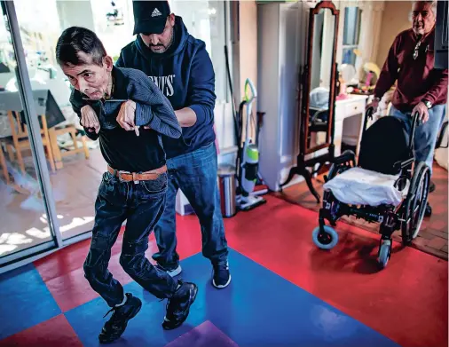  ?? JIM WEBER/THE NEW MEXICAN ?? Caregiver Jesus Pulido helps Matthew Allen take a few steps during daily physical therapy last week at his Santa Fe home. Matthew long has gone on walks with his family, including downtown, where his love for the universal language of music became apparent — via his dancing.