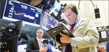  ??  ?? Trader Jonathan Niles (right), works on the floor of the New York Stock Exchange.